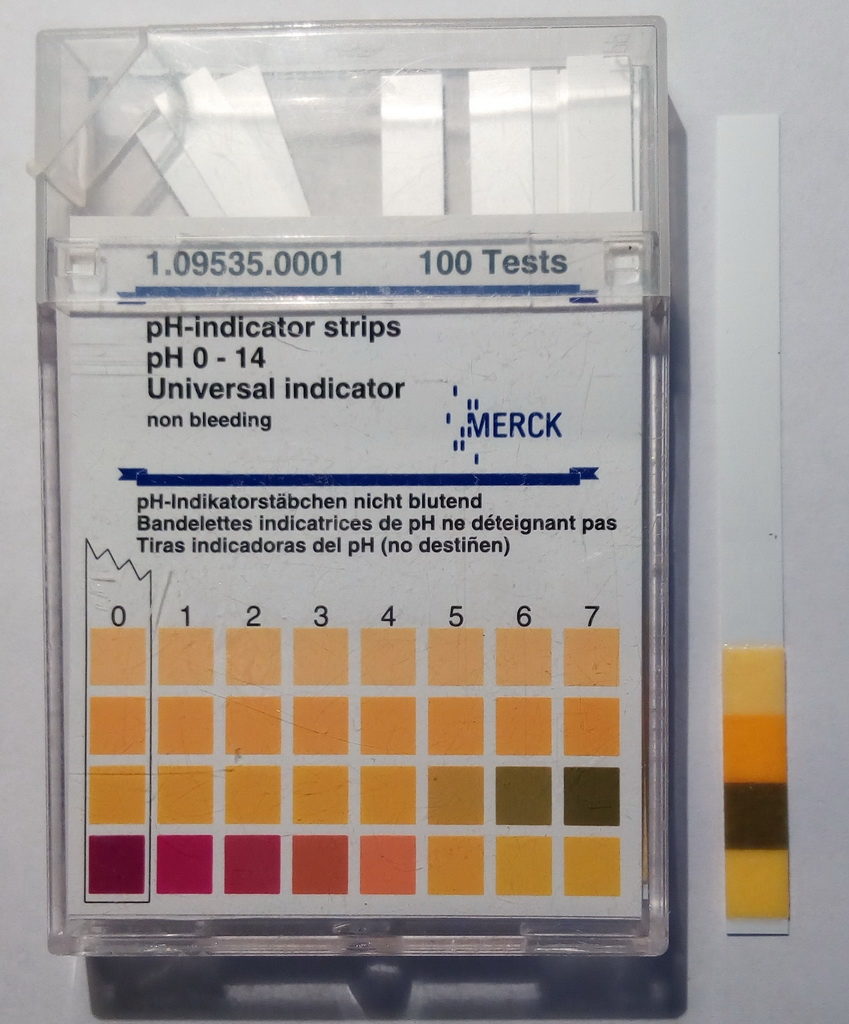 Muestra de saliva comparada con escala indicador de pH. Saliva sample compared with pH indicator scale.